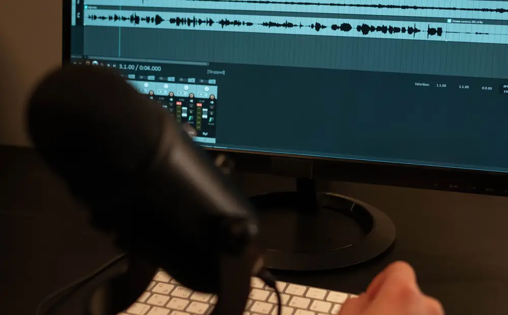 Podcast szerkesztése mikrofon és monitor mellett